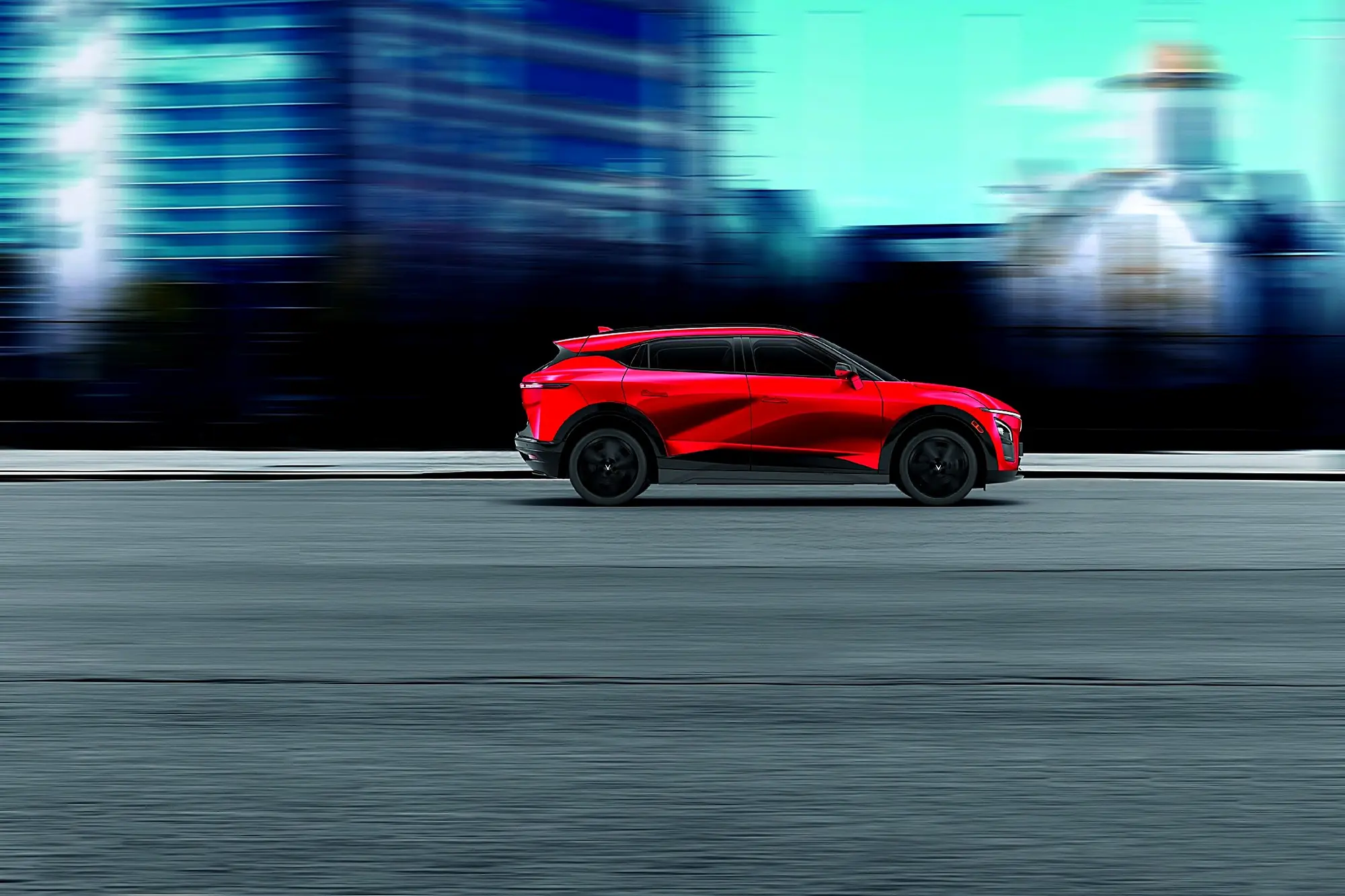 A red VinFast VF 7 driving through a blurred city street